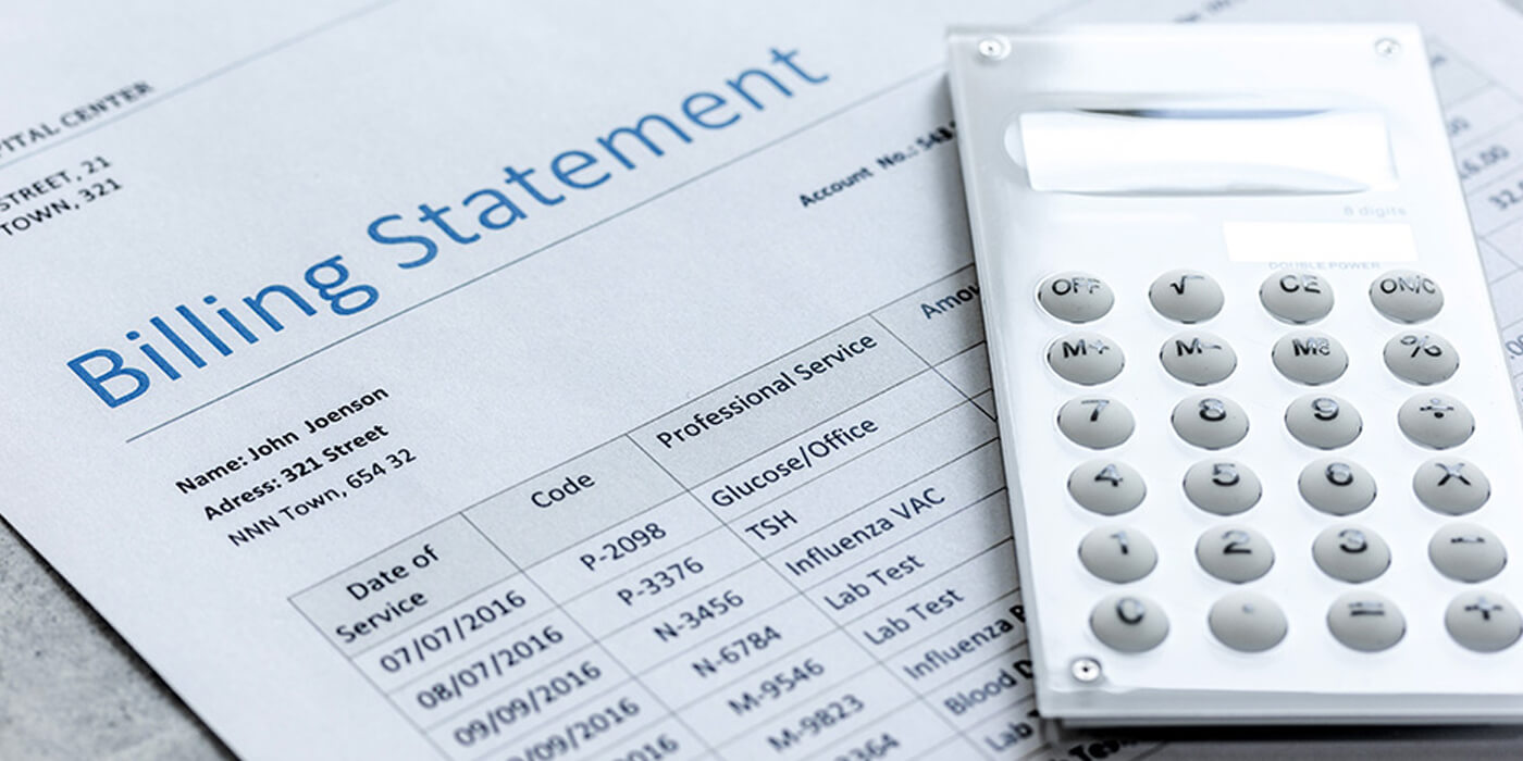 A close-up of a calculator adn a paper with the heading Billing Statement and a list of transactions.